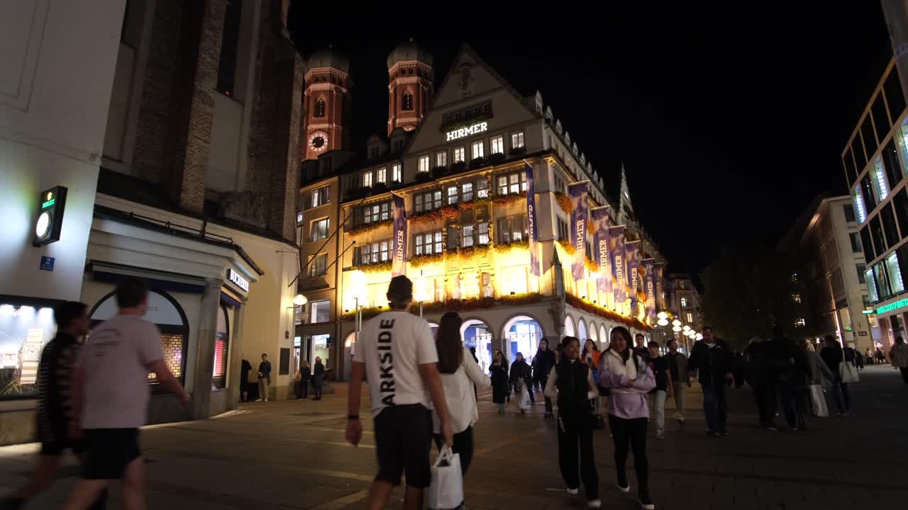 A night scene in the capital city, with people shopping, walking, and strolling, enjoying the scenic urban views and vibrant atmosphere.