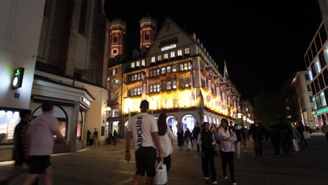 a night scene in the capital city, with people shopping, walking, and strolling, enjoying the scenic urban views and vibrant atmosphere.