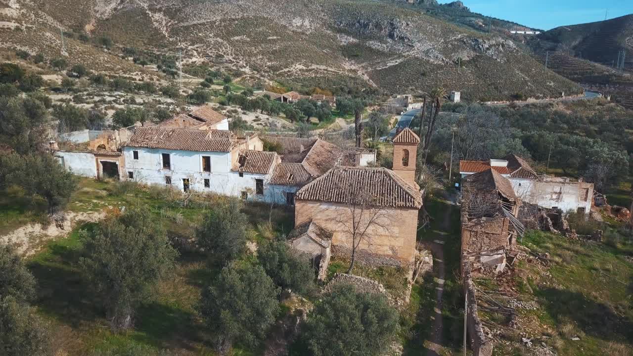 vista aérea de un pueblo abandonado con una iglesia rodeada de naturaleza en españa