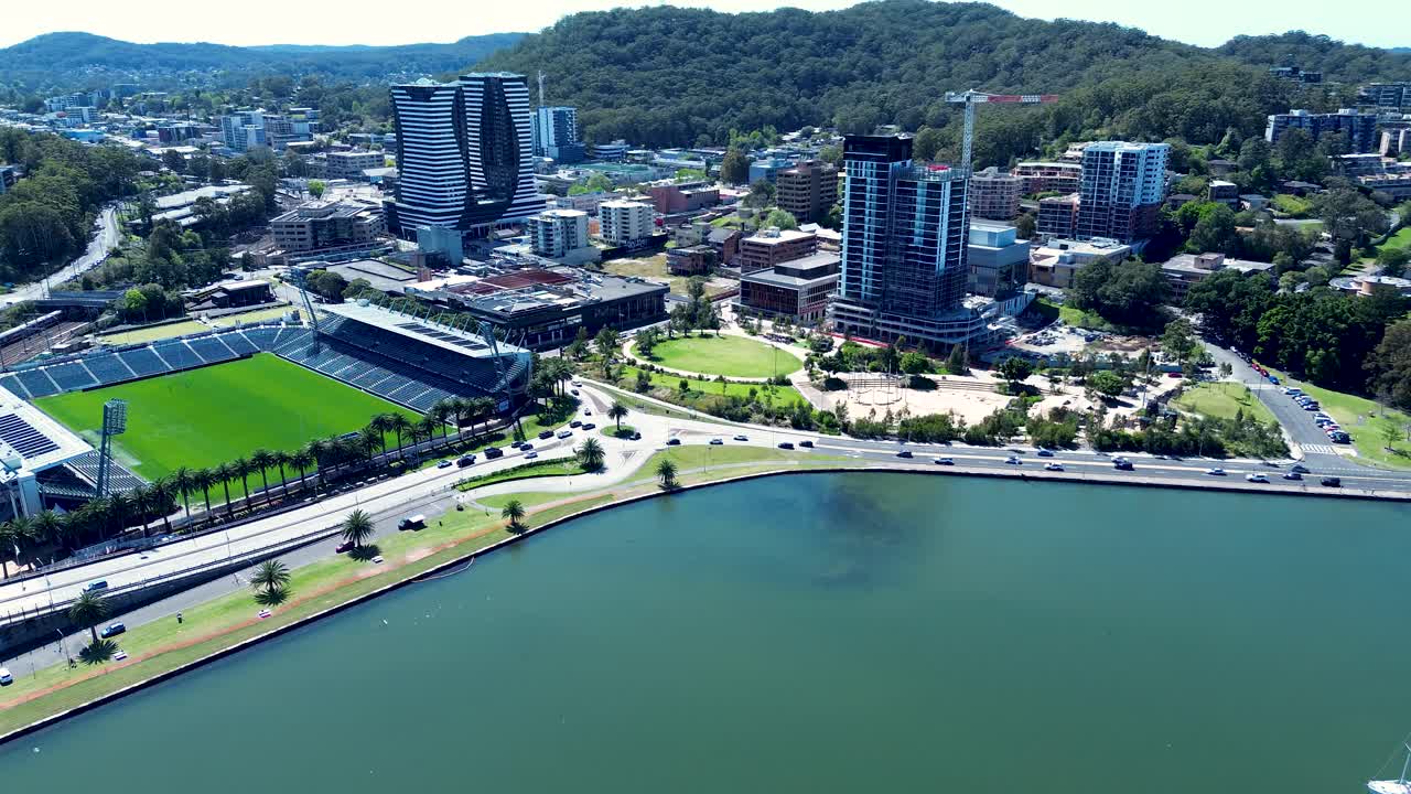 Drone aerial landscape of traffic and cars driving around busy roundabout with Gosford city buildings urban infrastructure and waterfront on Central Coast Australia travel transport and tourism