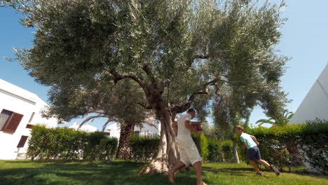 Child-and-dad-having-active-leisure-time-playing-tag-in-the-garden