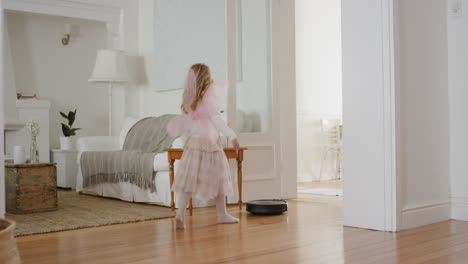 Niña-Feliz-Bailando-Juguetonamente-Con-Robot-Aspirador-Niña-Graciosa-Haciéndose-Pasar-Por-Bailarina-Divirtiéndose-Jugando-A-Disfrazarse-Usando-Traje-De-Ballet-Con-Alas-De-Hadas-En-Casa-4k