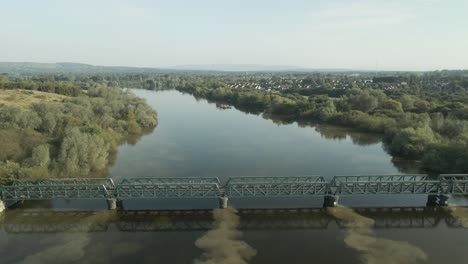 aerial view of a green metal bridge over a river