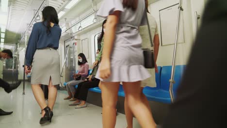 crowd of people wearing face mask on a crowded public subway train travel