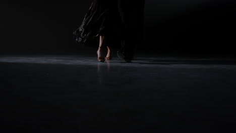 unknown man and woman legs dancing indoors. ballroom dancers feet moving floor.