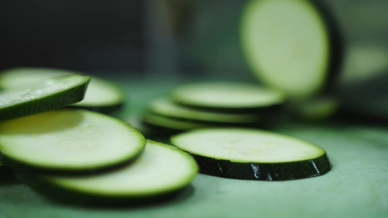 Ini menunjukkan seseorang mengiris zukini menjadi potongan seukuran gigitan yang sempurna. Ini diambil dengan kecepatan normal dengan efek buram gerakan alami.