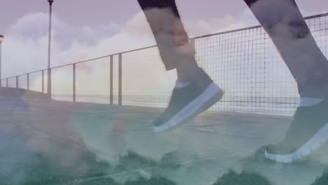 Animation-of-clouds-over-african-american-man-running-at-beach