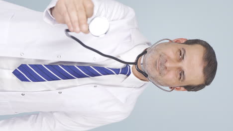 vídeo vertical del médico escuchando a la cámara con un estetoscopio.