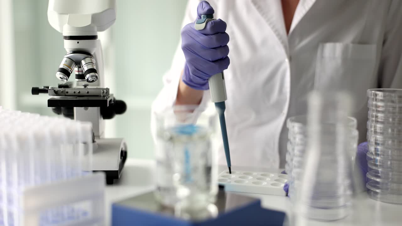 Chemist drips reagent while solution mixes on shaker