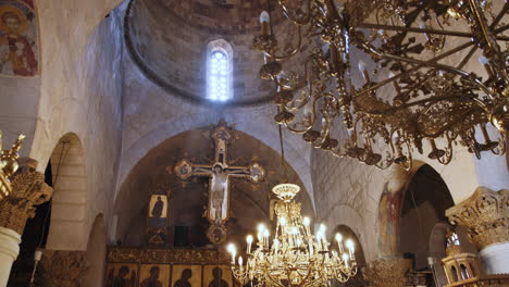 interior of a historic church with a cross and chandelier