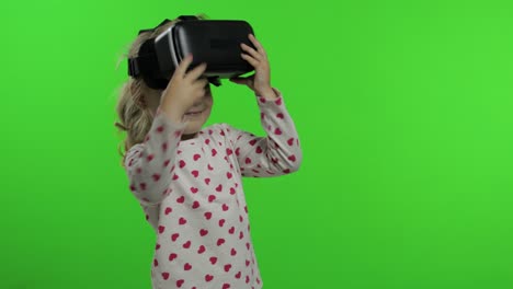 Child-girl-using-VR-headset-helmet-to-play-game.-Watching-virtual-reality-3d-360-video.-Chroma-key