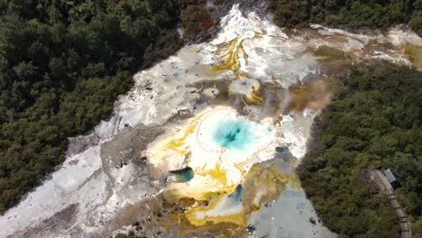 spectacular aerial reveal of turquoise hot spring steaming in orakei koraku - geothermal active area in new zealand