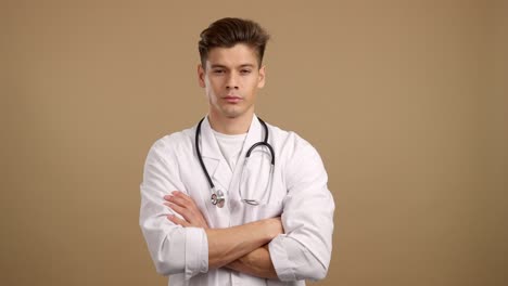 young male doctor with stethoscope and crossed arms