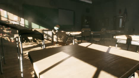 view to classroom with tables and small blackboard and grungy walls