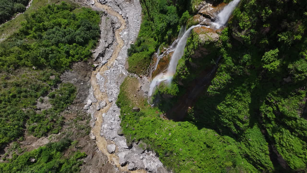Waterfall from cliff transforms into a river in Nepal and Drone trekking trails aerial shows adventurous travel tourism of Nepali aesthetics lush greenery environmental protection happy mother nature