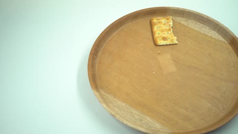 galleta de navidad sobre el plato de madera, tenedor y cuchara con fondo blanco.
