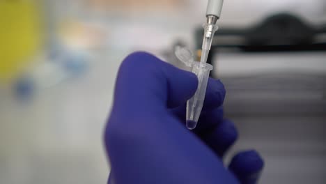 scientist draws samples from a tube late at night