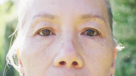 늦은 동작으로 정원에서 눈을 이는 아시아 여성의 눈의 초상화