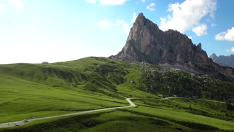 small country road up in the mountains towards a high cliff, passo di giau, alps, dolomiti, belluno, italy