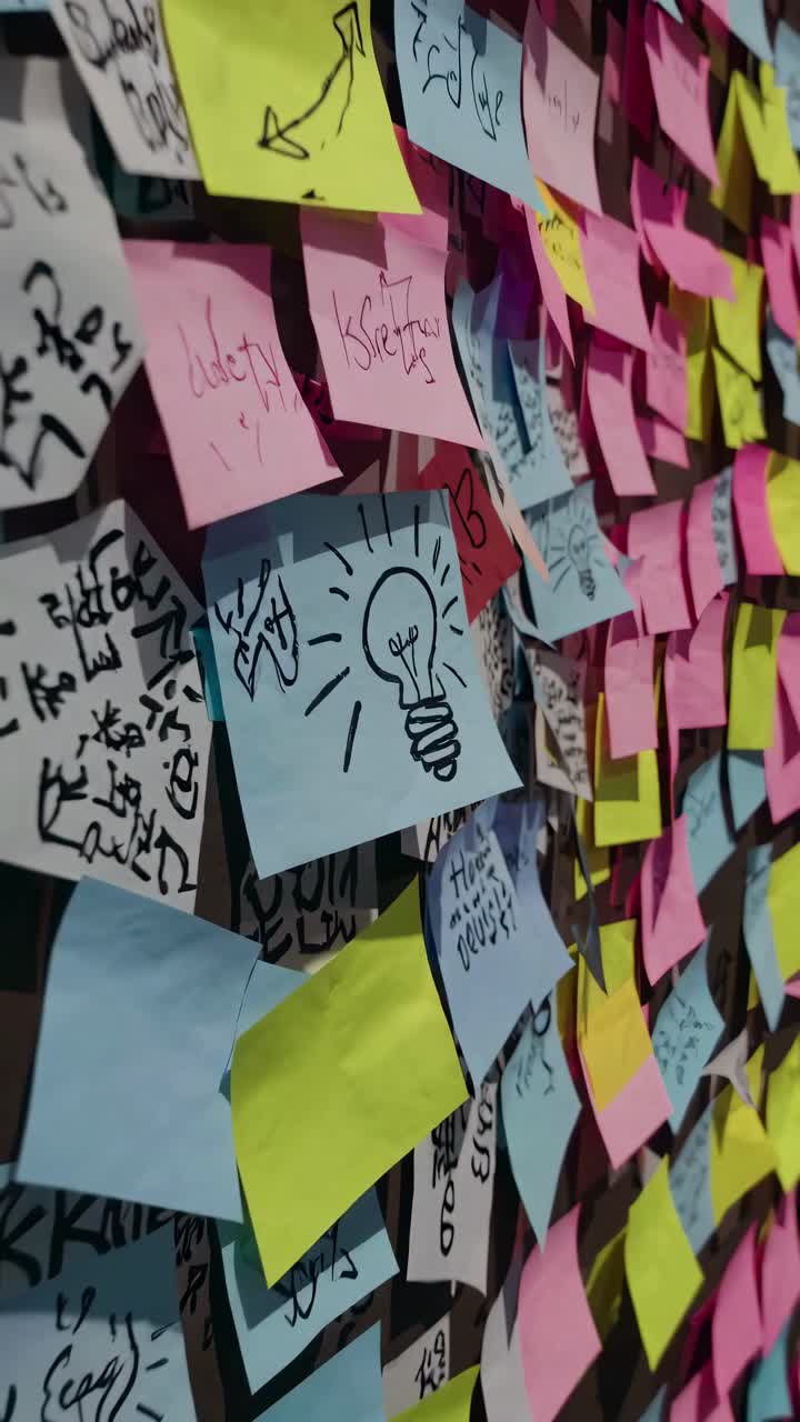 A vibrant wall covered in colorful sticky notes, captured from a side angle