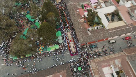 Vista-Aérea-De-Devotos-Y-Cucuruchos-Que-Llevan-Una-Gran-Carroza-Que-Representa-A-Cristo-Llevando-La-Cruz-Durante-La-Procesión-De-Semana-Santa-En-Antigua,-Guatemala