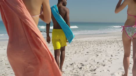 jonge volwassen vrienden lopen langs een strand 4k