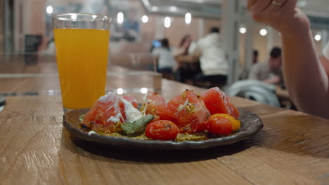 comiendo un plato vegetariano de tomate en el restaurante