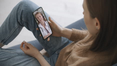 Mujer-Que-Usa-Una-Aplicación-Médica-En-Un-Teléfono-Inteligente-Consultando-Con-Un-Médico-A-Través-De-Videoconferencia.-Mujer-Que-Utiliza-El-Chat-En-Línea-Para-Hablar-Con-Un-Terapeuta-Familiar-Y-Comprueba-Posibles-Síntomas-Durante-La-Pandemia-Del-Coronavirus.