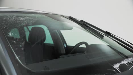 Windscreen-wiper-fluid-being-squirted-on-the-windscreen-and-wiped-clean-by-the-windscreen-wipers