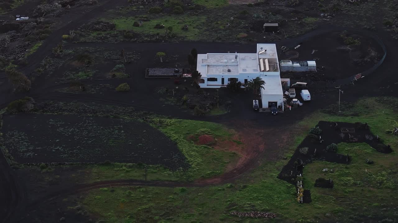Udforskning af Lanzarotes vulkanske landskab med udsigt til en hvid bygning