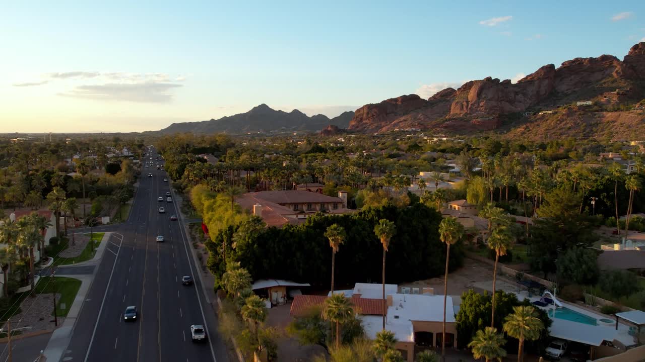 inclinación aérea sobre palmeras revelando casas en la base de la montaña camelback cerca de scottsdale, arizona