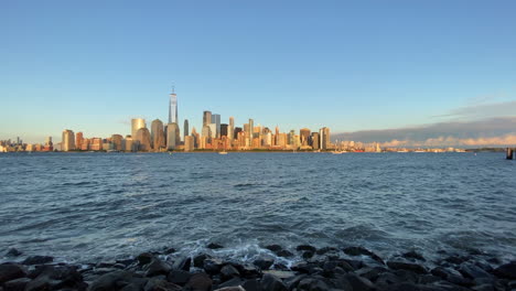 a view of the new york city skyline and the hudson river at sunset