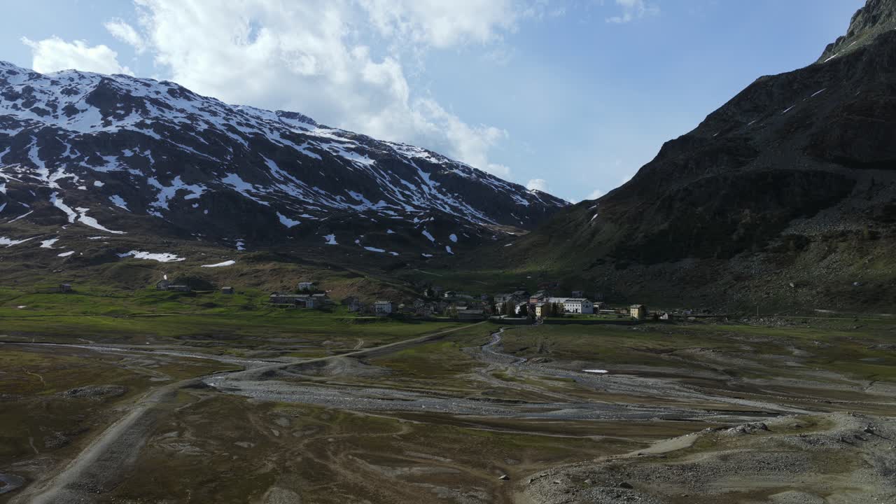 Scenic view of a village nestled within an alpine valley surrounded by mountains at Montespluga