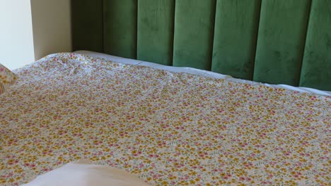 making a bed with floral patterned sheets