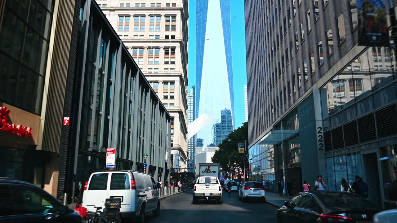 New York, USA, 5 August 2025: Street view towards One World Trade Center in Manhattan. Narrow city street with traffic and modern skyscraper in the background