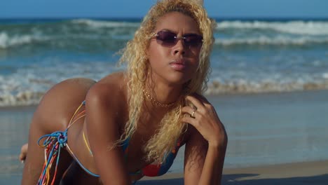 at a tranquil caribbean beach, a young hispanic girl in a bikini immerses herself in the refreshing embrace of the ocean waves with blue skies in the background