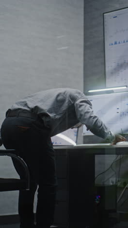 financial analyst suffering from financial crisis, yelling in phone, analyzing real-time market charts in office. african american businessman furious about stock market collapse. vertical shot.