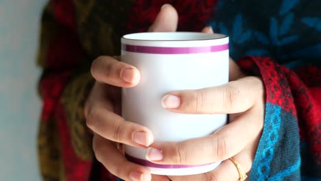 woman's hands holding a warm mug