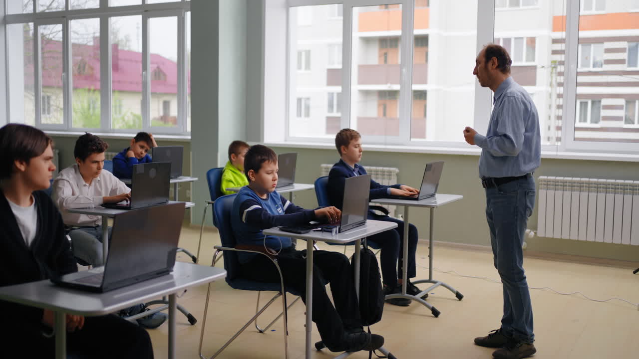 maestro instruyendo a los estudiantes en una clase de computadora