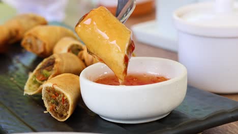 spring roll dipped into sauce repeatedly