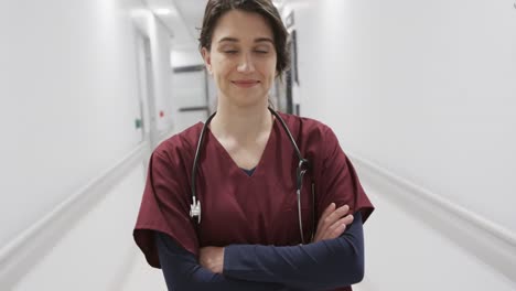 Portrait-of-happy-caucasian-female-doctor-in-hospital-corridor,-slow-motion