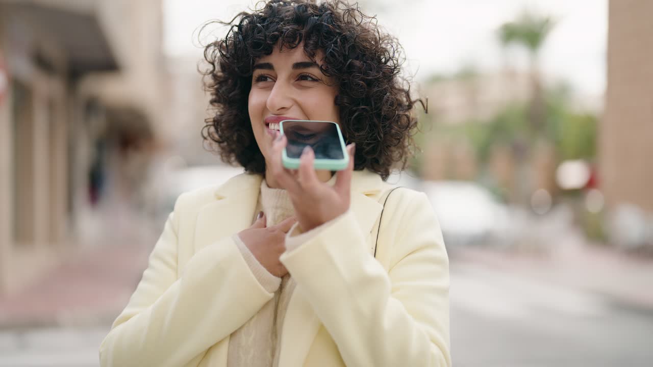 Young woman smiling confident talking on the smartphone at street