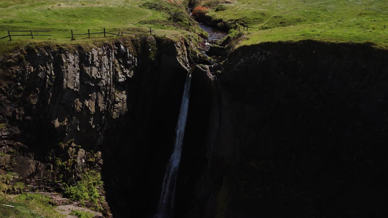 Aerial view of the beautiful, hidden gem Spekes Mill Mouth Waterfall located next to the Celtic Sea in Devon, UK