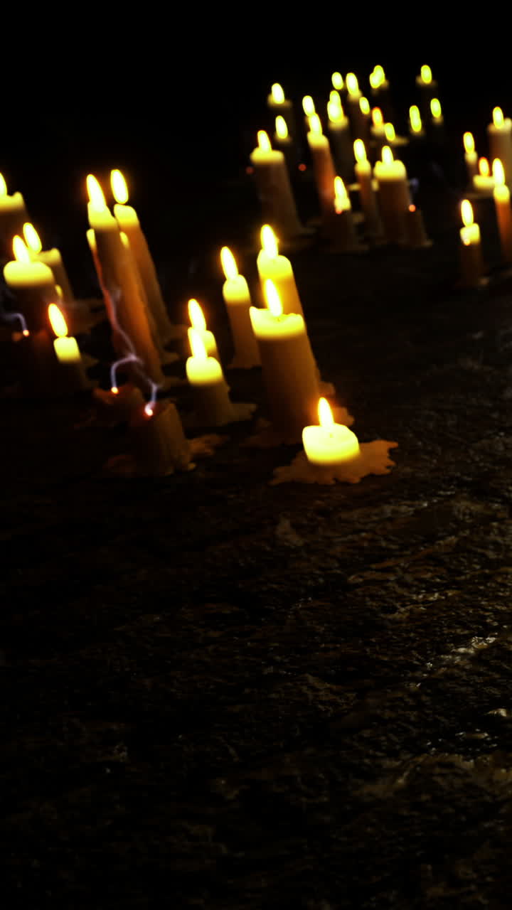 Candele posizionate su terreno scuro durante un raduno serale in un luogo tranquillo