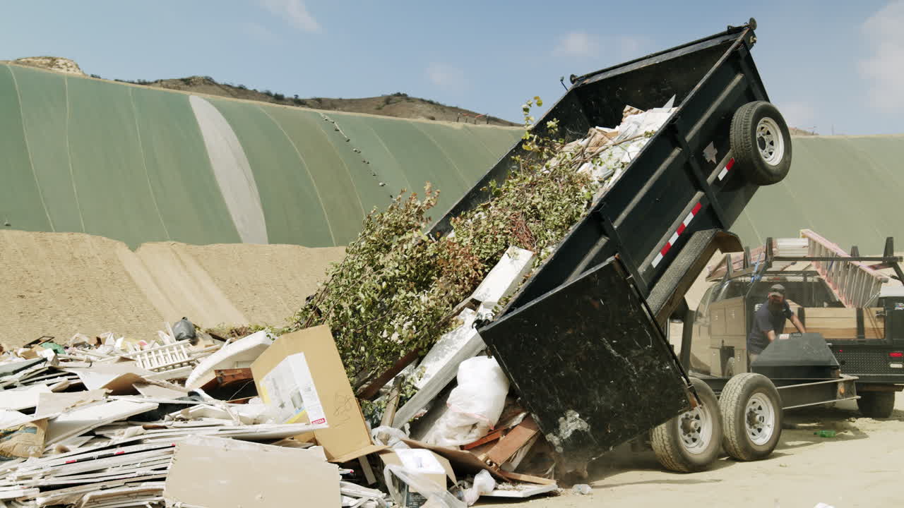 Dumpster dumping waste at a landfill