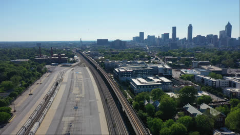 drone wide shot of suburb buildings near tracks in summer