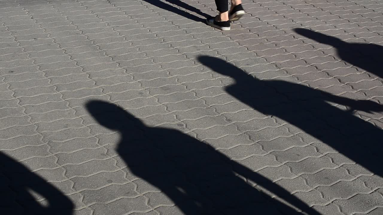 Light and shade, reflection of people in beams of the setting sun. People and shadows from them