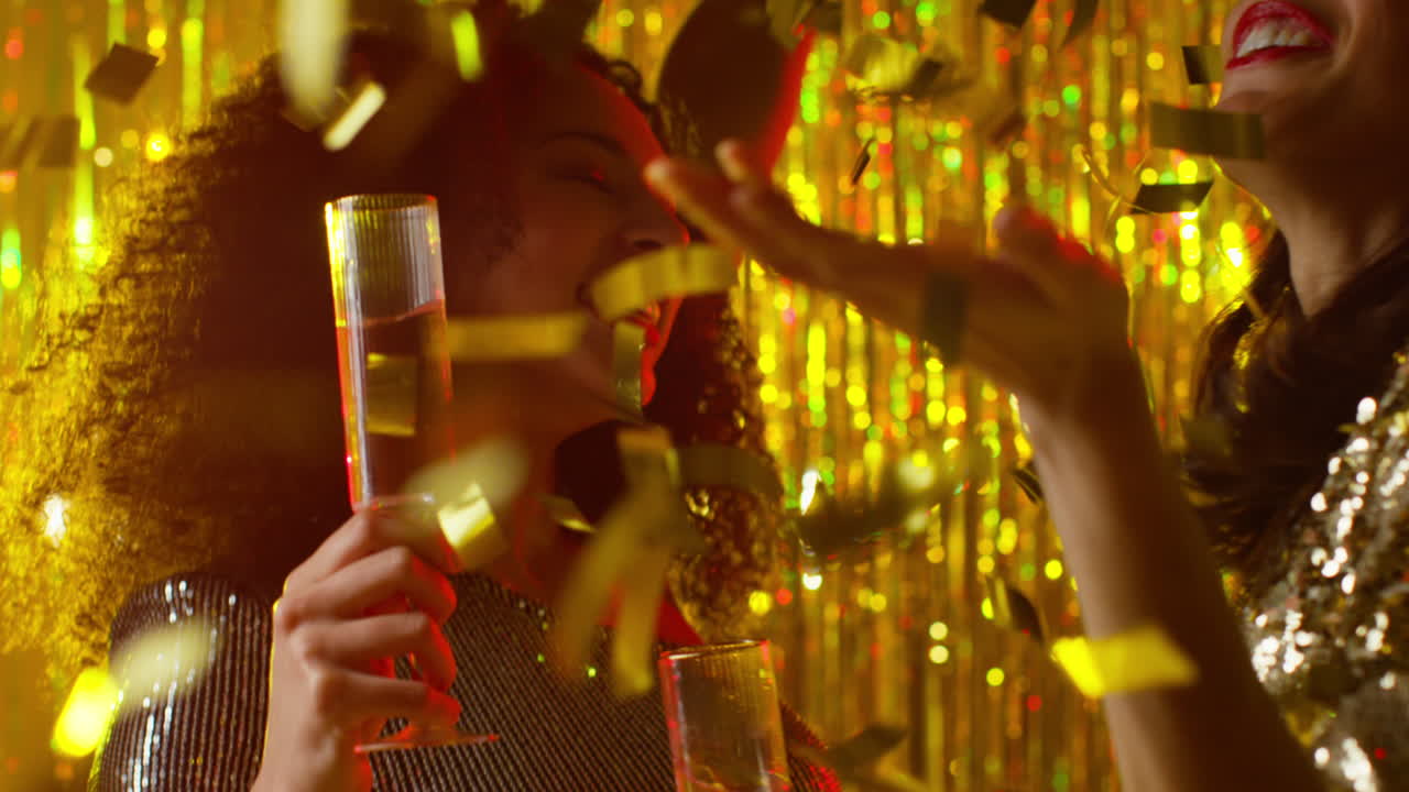 Close Up Of Two Women Dancing In Nightclub Bar Or Disco Drinking Alcohol With Falling Gold Confetti 3