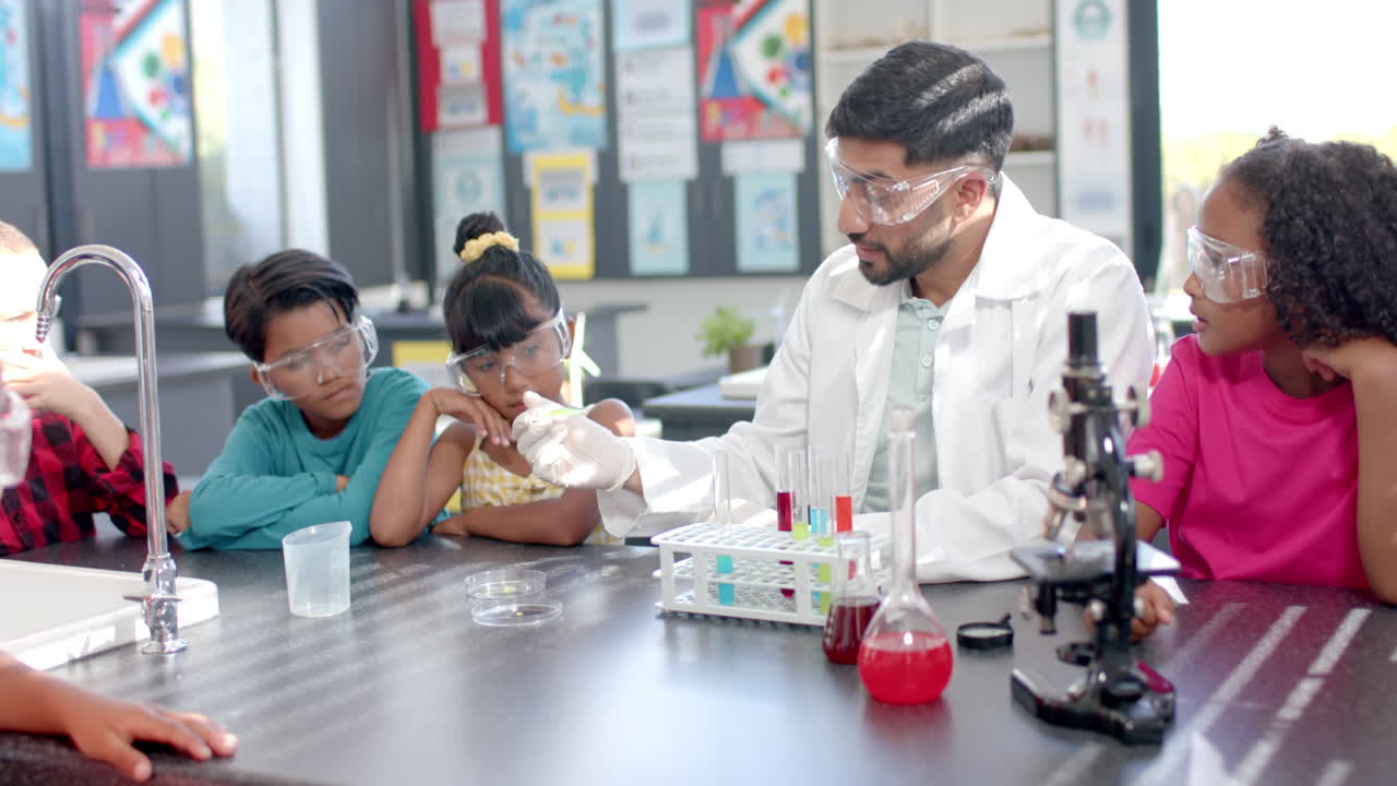 In a school laboratory, a biracial teacher demonstrates a science experiment