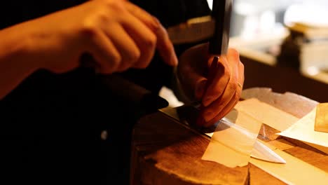 artesano formando una hoja de cuchillo con un martillo